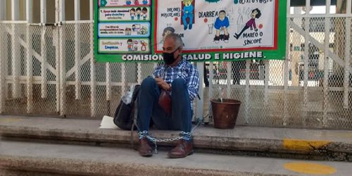 Director se encadena a puerta de primaria; denuncia intención de despido injustificado